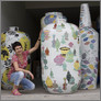 [thumbnail of Felicity Aylieff amongst the pots in storage, awaiting transportation to the UK]